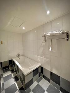 a bathroom with a tub and a checkered floor at 喜客商旅 Seeker Hotel - Sanchong in Taipei
