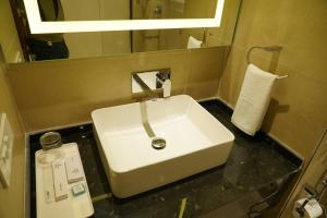 a bathroom with a white sink and a mirror at The Park Regency Hotel in Moga
