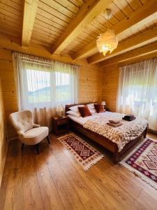 een slaapkamer met een bed en een stoel in een hut bij Malinowa Chata in Cisna