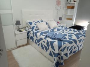 1 dormitorio con 1 cama azul y blanca con alfombra en apartamento con jardín privado a 300 metros de la playa, en Soto de la Marina