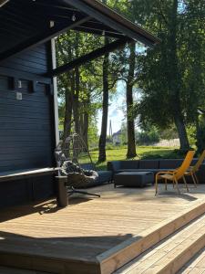 a patio with a couch and chairs on a wooden deck at Igates pils Brīvdienu māja in Myza Igate