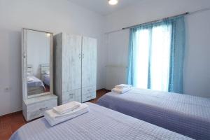 - une chambre avec 2 lits, un miroir et une commode dans l'établissement Μονοκατοικία με θέα τη Χώρα, à Skiros