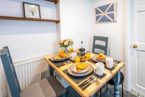 a wooden table with plates of food on it at Pass the Keys Stylish newly renovated Victorian 2 bedroom house in Shrewsbury