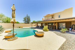 a house with a swimming pool and an umbrella at Secluded Mesa Retreat with Outdoor Kitchen and Bar! in Mesa