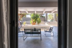 a room with a table and chairs and a patio at Greyt Apartments Glyfada in Athens