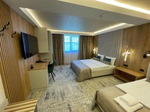 ein Hotelzimmer mit 2 Betten und einem Flachbild-TV in der Unterkunft Hotel RK in Ghimbav