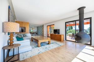 a living room with a couch and a fireplace at Unique Villa -1 km to Beach, private Natural pool, Tennis Court & Jumping Mat in Sagres