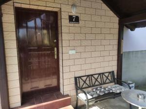 a bench sitting in front of a building with a door at Pod Modrzewiem in Milicz