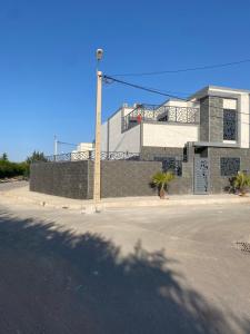 een gebouw met palmbomen voor een straat bij Villa Aziza piscine privée in Oujda