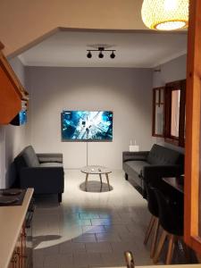 a living room with couches and a tv on the wall at Meltemi Apartments in Asprovalta