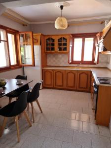 a kitchen with wooden cabinets and a table and chairs at Meltemi Apartments in Asprovalta