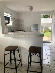 a kitchen with two bar stools and a counter top at Villa les Poinsettias in Saint-Pierre