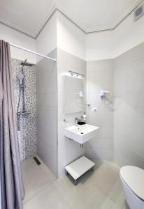 a white bathroom with a sink and a shower at Hotel JoAn in Sarandë