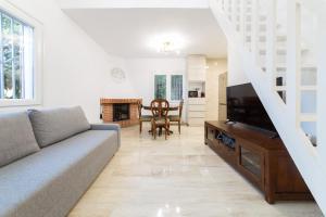 uma sala de estar com um sofá e uma televisão em SILOM HOUSE em Sant Pere de Ribes