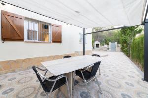 uma mesa branca e cadeiras num pátio em SILOM HOUSE em Sant Pere de Ribes