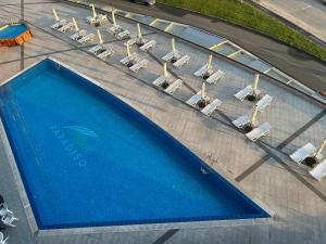 een uitzicht over een blauw zwembad met stoelen bij Sea View Private Studio Paradiso B 508 in Nesebar