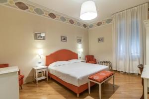a hotel room with a bed and a chair at Casa Isolani, Piazza Maggiore in Bologna