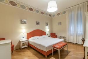 ボローニャにあるカーサ イゾラーニ ピアッツァ マッジョーレのベッドと椅子付きのホテルルーム