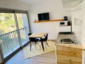 a small kitchen with a table and a balcony at Le Port Tamaris in La Seyne-sur-Mer