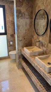 a bathroom with two sinks and a toilet at Family Vacation Villa Rezevici in Budva