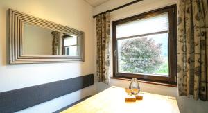 een kamer met een raam, een spiegel en een tafel bij Seehaus Verena in Weissensee