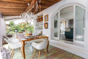 uma sala de jantar com uma mesa de madeira e cadeiras brancas em Le Rondini- Solo Adultos em Montrás