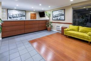 a waiting room with a yellow couch and a television at Super 8 by Wyndham Williamsburg/Historic Area in Williamsburg