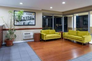 a lobby with two yellow chairs and a fireplace at Super 8 by Wyndham Williamsburg/Historic Area in Williamsburg