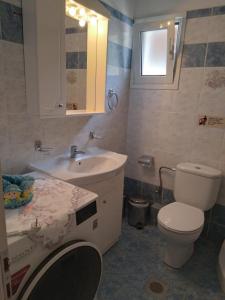 a bathroom with a white toilet and a sink at Makis Studios & Apartments in Poros