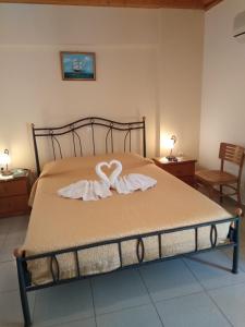 una camera con un letto con due cigni bianchi di Makis Studios & Apartments a Póros