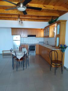 a kitchen with wooden cabinets and a table and chairs at Makis Studios & Apartments in Póros Kefalonias