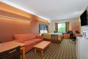 Super 8 by Wyndham Columbus West في كولومبوس: غرفة في الفندق مع أريكة وسرير