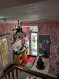 ブラックプールにあるRossdene Houseのピンクの壁紙を用いたキッチンの上から見える