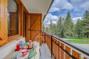 d'un balcon avec une table et des chaises. dans l'établissement Studio Abete Rosso 500m From Ski - Happy Rentals, à Sauze dʼOulx