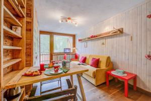 ein Wohnzimmer mit einem Tisch und einem Sofa in der Unterkunft Studio Abete Rosso 500m From Ski - Happy Rentals in Sauze dʼOulx