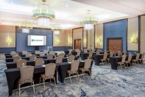 a conference room with tables and chairs and a screen at Wyndham Indianapolis West in Indianapolis