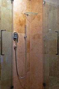 a shower stall with a glass door with a shower constructor at Seehaus Verena in Weissensee
