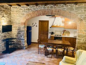 une cuisine et une salle à manger avec une arche en pierre dans l'établissement Agriturismo Tramonti, à Castiglione di Garfagnana