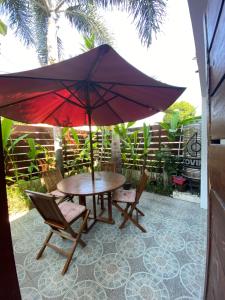 a table and chairs with an umbrella on a patio at Fullhouse in Mataram