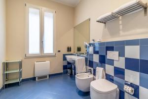 a blue and white bathroom with a toilet and a sink at Casa Isolani Luxury Rooms Piazza Maggiore in Bologna +68 photos