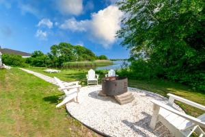 a picnic area with two white benches and a fire pit at Cape Sands Inn in West Yarmouth