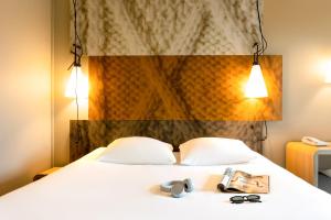 una habitación de hotel con una cama con dos pares de gafas en ibis Leuven Centrum, en Lovaina