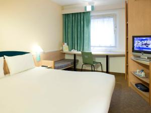 Habitación de hotel con cama, escritorio y TV. en ibis Hull City Centre en Hull