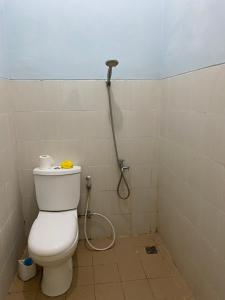 a bathroom with a toilet and a shower at Fullhouse in Mataram