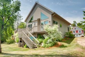 a house with a staircase in front of it at Lakefront Wisconsin Getaway with Kayak and Boat Dock! 