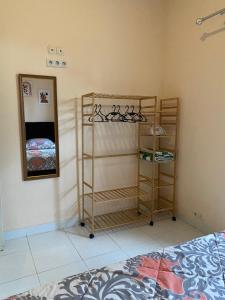 a room with a bed and a mirror and shelves at Fullhouse in Mataram