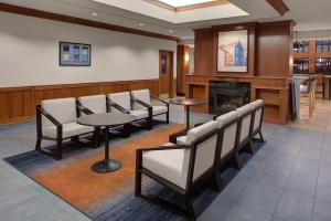 a waiting room with chairs and tables and a fireplace at Hyatt House Philadelphia/Plymouth Meeting in East Norriton