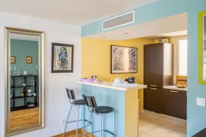 a kitchen with a bar and two stools at The Good Mother - Vue sur Notre Dame de la Garde in Marseille