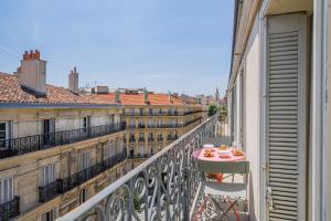 a balcony with a table with two cups on it at The Good Mother - Vue sur Notre Dame de la Garde in Marseille