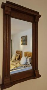 a mirror reflecting a bed with pillows on it at FLORESTI HOUSE 21 in Roandola +6 photos